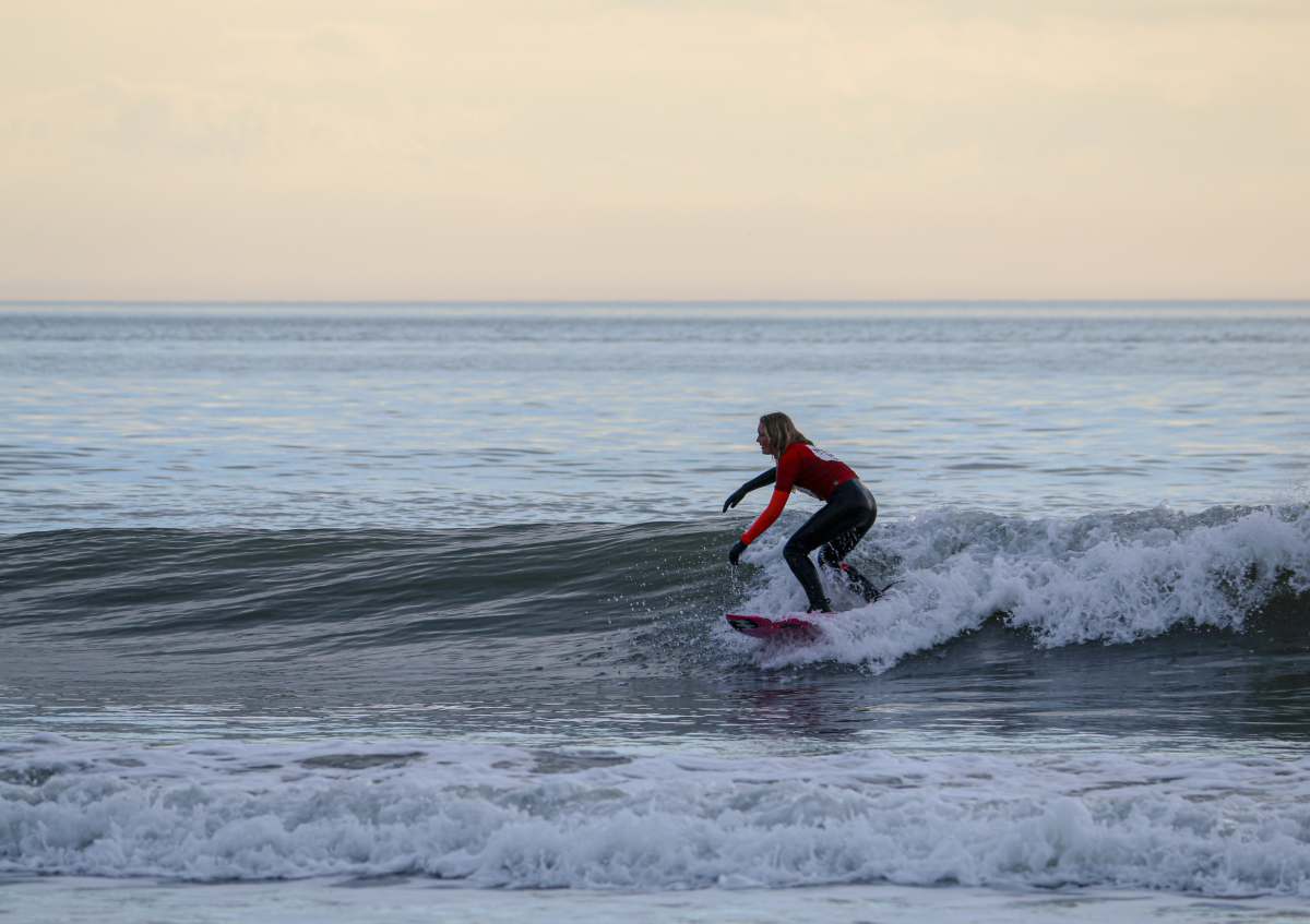 surfing croyde bay man in red shirt surfing on sea waves during daytime baggy surf lodge